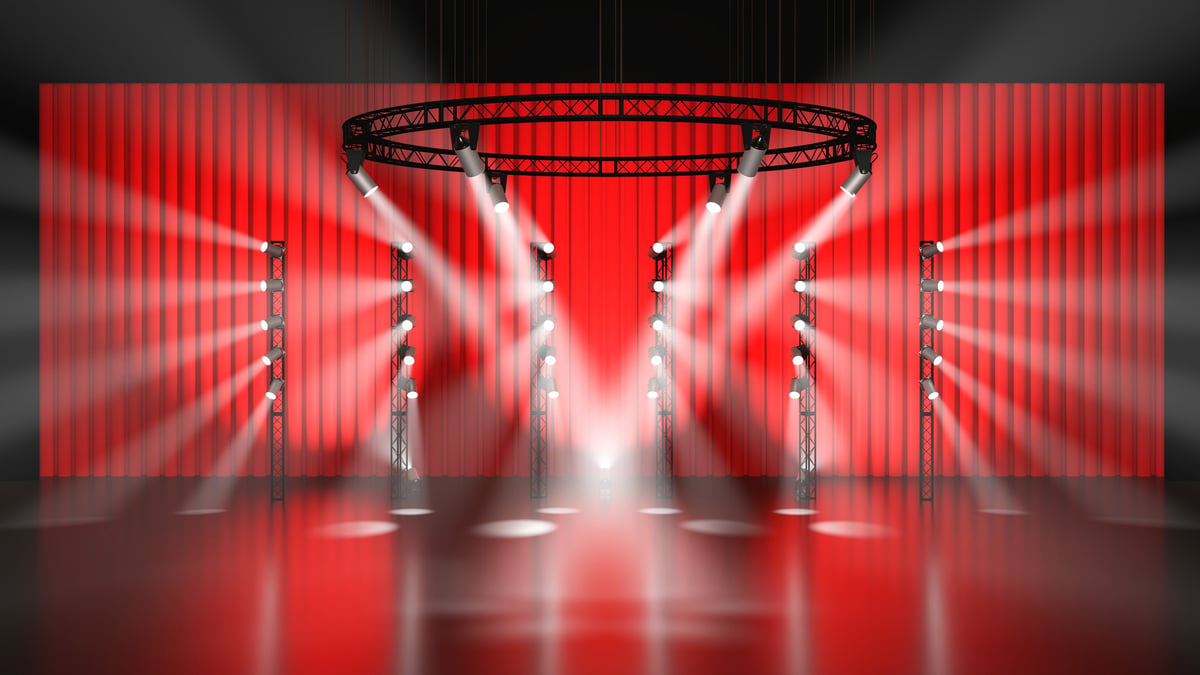 A grand stage with spotlights awaiting a runway presentation